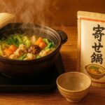 土鍋に湯気の立つ野菜たっぷり寄せ鍋と「寄せ鍋」と書かれた鍋の素パウチ、取り皿とおたまが木のテーブルに並ぶ和風料理の写真