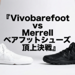 白いシューズと黒いシューズを履いた男性の足元を横並びで比較している写真。中央に「Vivobarefoot vs Merrell ベアフットシューズ頂上決戦」という日本語タイトルが大きく表示されている。