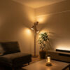 暖色の間接照明で落ち着いた雰囲気に整えたモダンなリビング。フロアランプ、テーブルランプ、テレビボード照明、観葉植物がある空間