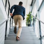 オフィスの階段を激しく駆け上がるビジネスパーソン。