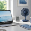 明るい在宅ワーク用デスクに、ノートPC、卓上ファン、温湿度計、蓋つきマグカップが並ぶ快適な作業環境